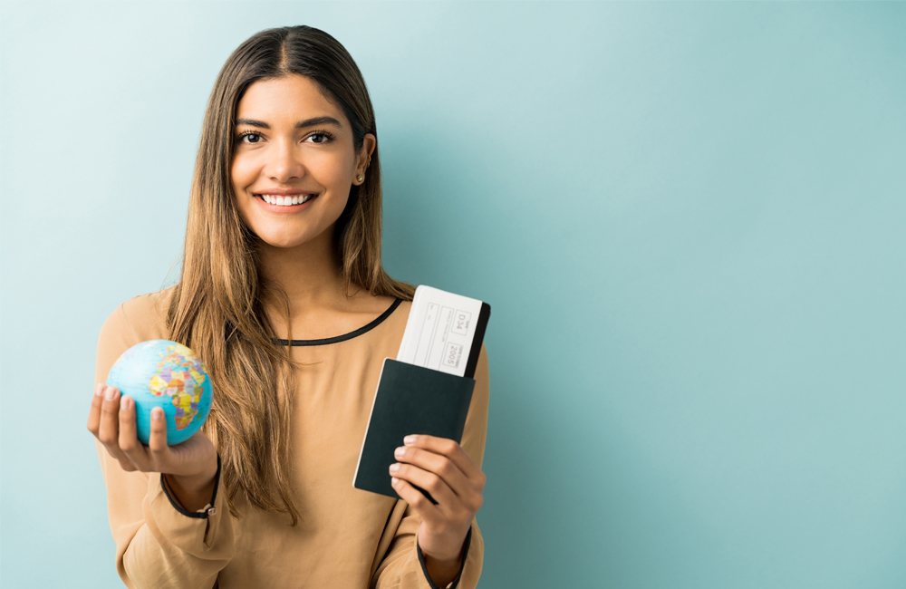 Seguro viagem exterior, mulher sorrindo com um passaporte em uma mão e um globo na outra