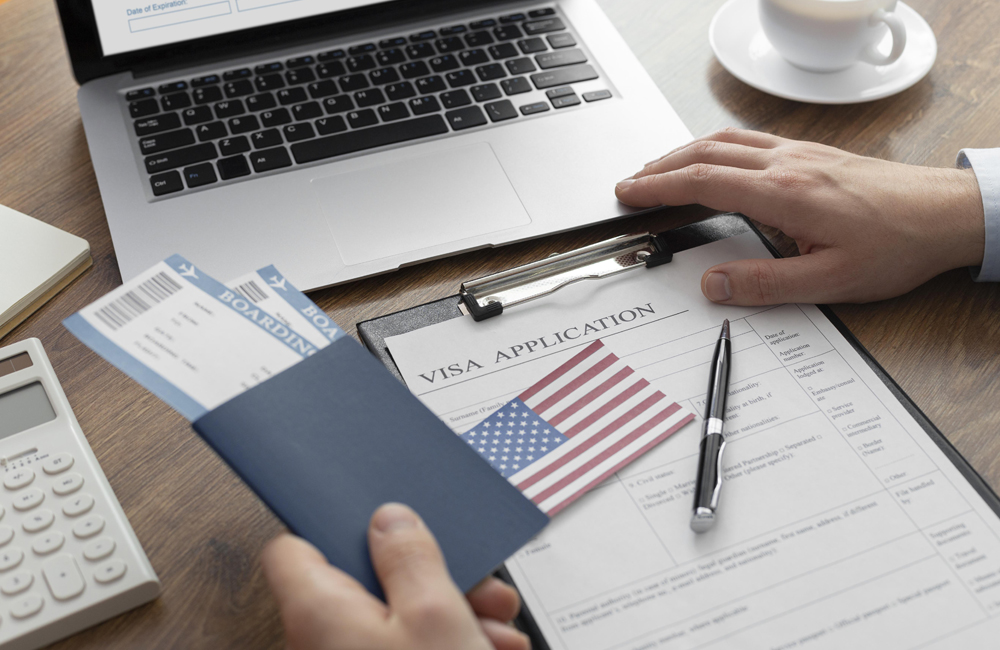 pessoa preenchendo um formulário de aplicação de visto em frente ao notebook. 